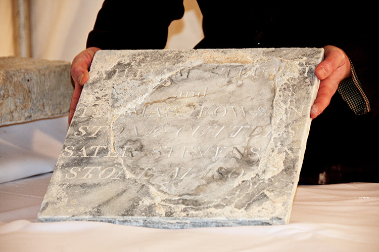 Lance Humphries, Chair of Restoration Committee, Mount Vernon Place Conservancy, demonstrating wellpreserved marble lid of the time capsule bearing names of the original stone cutters and the stone mason.